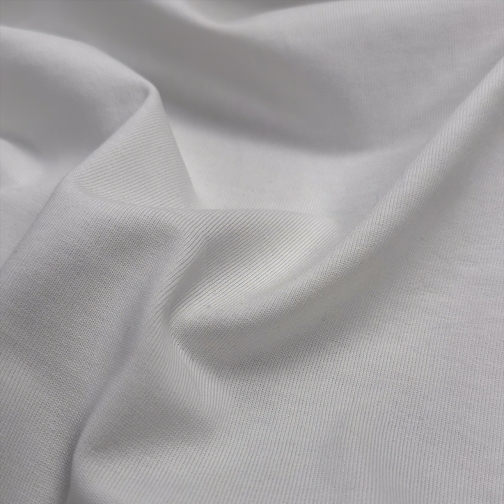 Nahaufnahme des dichten, feinen Baumwolljerseys mit gleichmäßiger Maschenstruktur und weichem Griff.